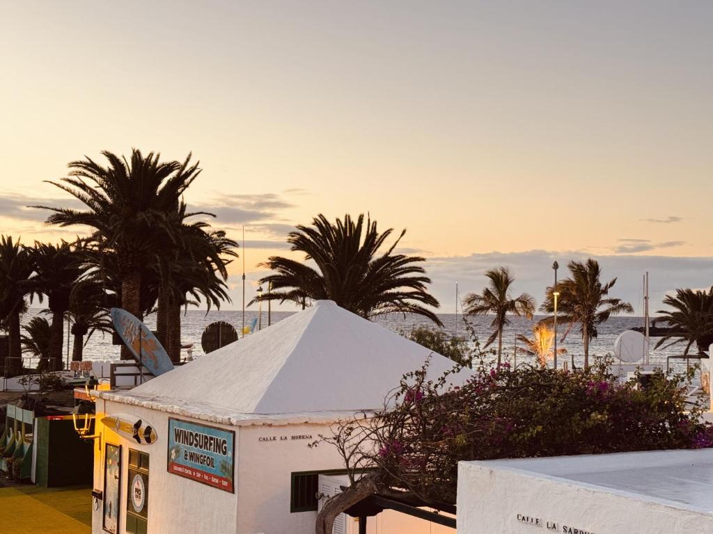 a white tent with palm trees in the background at Casita Malvika in Costa Teguise