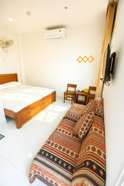 ein Schlafzimmer mit einem Bett und einem Bett in der Unterkunft Nguyên Thanh Hotel in Ho-Chi-Minh-Stadt