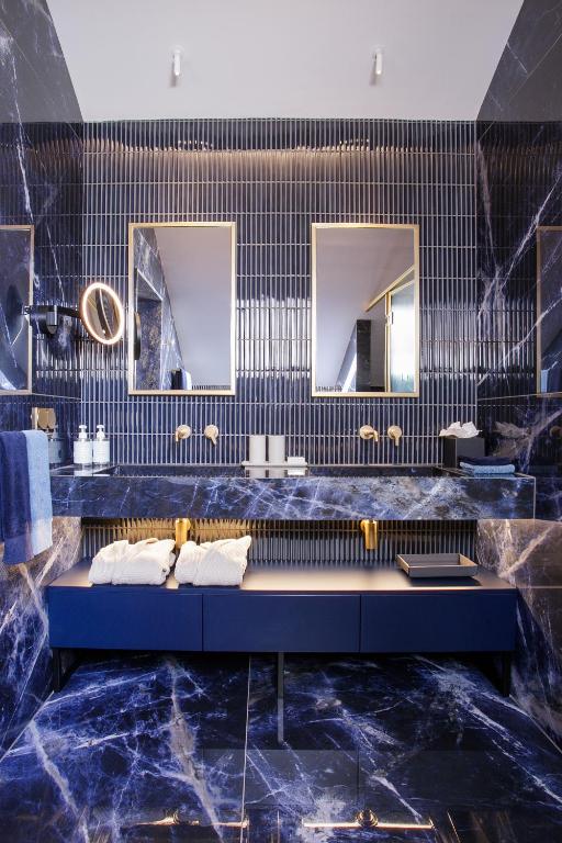 A dramatic marble bathroom vanity with twin sinks and separate mirrors.