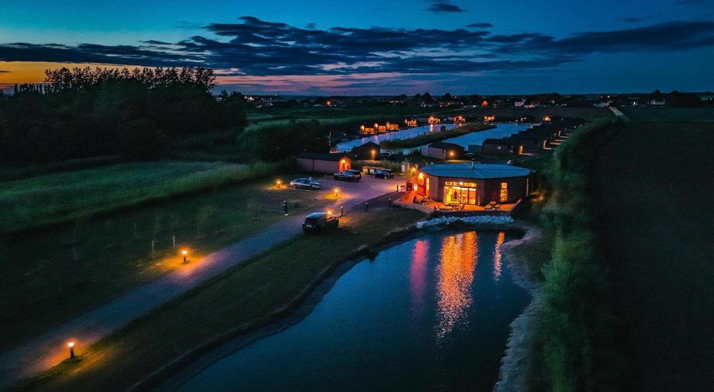 une vue d'une rivière la nuit avec des lumières dans l'établissement Lakeside Fishing Retreats, à Boston