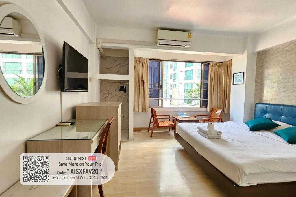 a bedroom with a bed and a desk in a room at Crown BTS Nana Hotel in Bangkok
