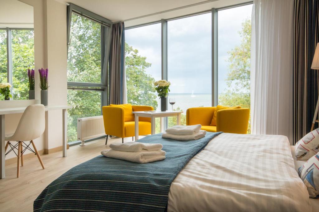 a bedroom with a bed with yellow chairs and windows at Tawerna Rybaki in Sopot
