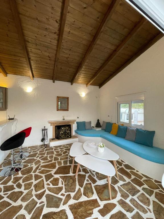 a living room with a blue couch and a fireplace at Casa Fouli - Eretria in Eretria