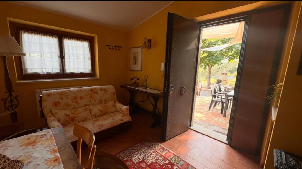 un salon avec un canapé et une porte coulissante en verre dans l'établissement Domus Janas, à Scandriglia