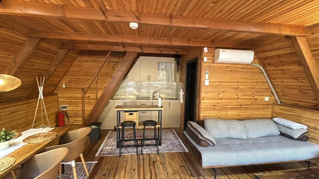 a room with a couch and a kitchen in a cabin at Merce Bungalov in Sakarya