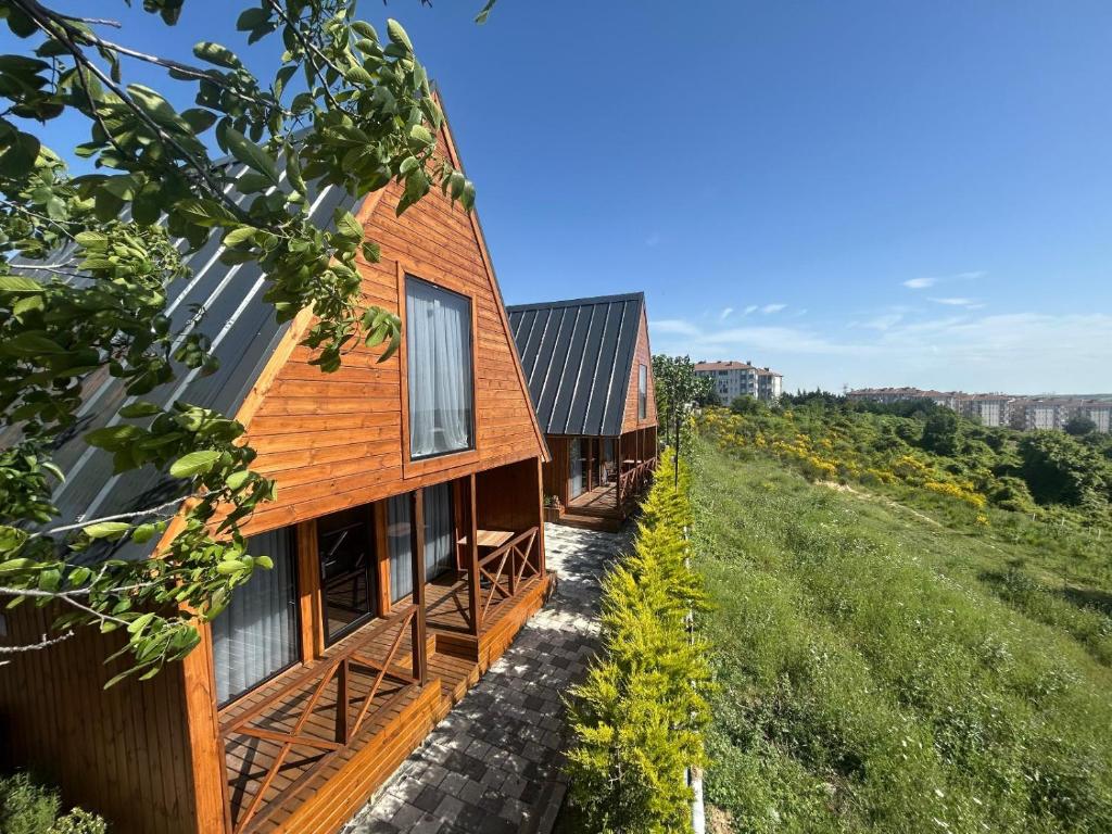 a wooden house on a hill next to a field at Navy Inn in Arnavutköy