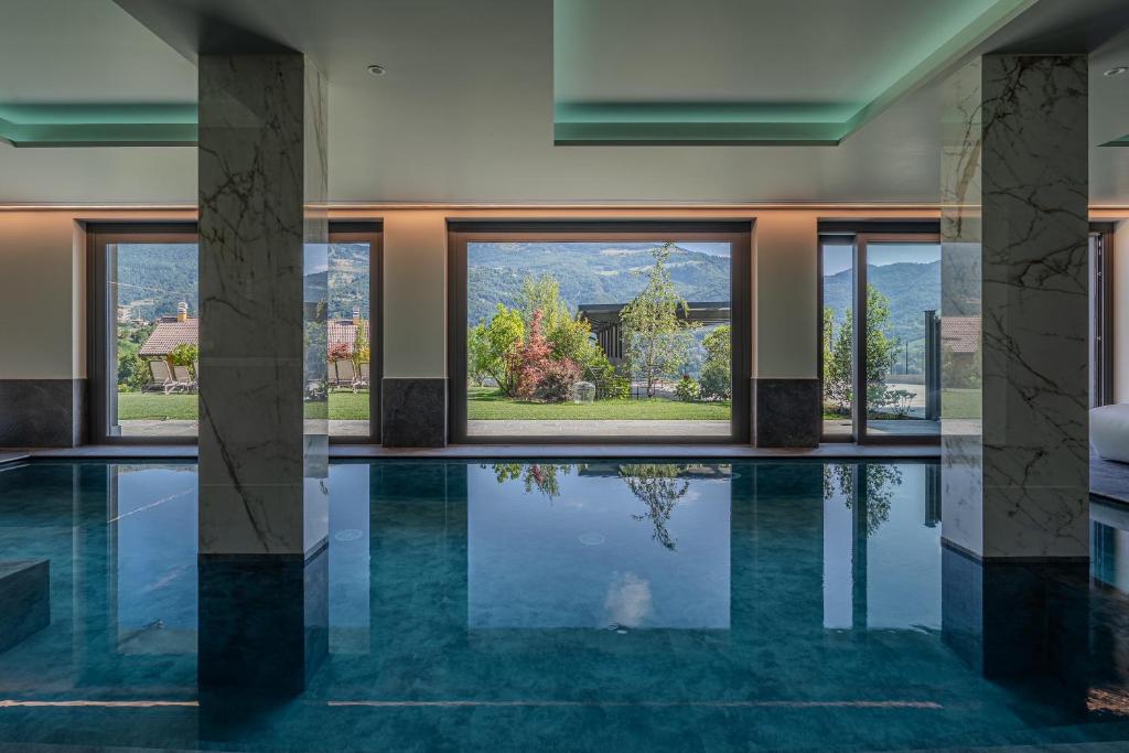 a swimming pool in a house with windows at Miramontino Mountain Suite in Rota d'Imagna