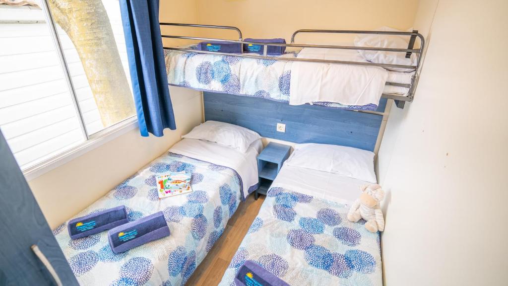 two bunk beds in a room with a window at Happy Camp mobilehomes in Camping Apollonia in Plakias