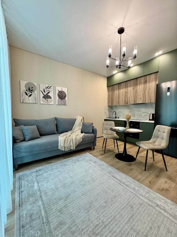 a living room with a blue couch and a table at A-Six Apartment ЖК Достар in Karagandy