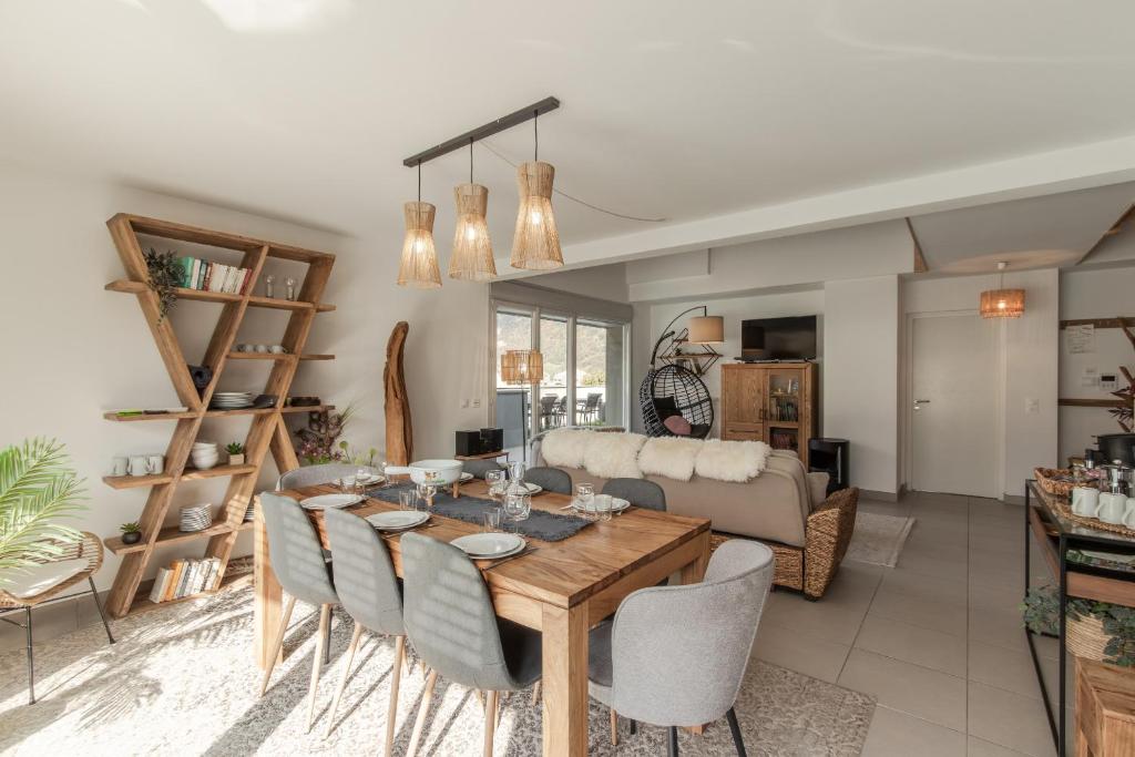 a dining room and living room with a table and chairs at Le Méribel - Terrasse 83m2 - Vue Mont-Blanc in Sallanches