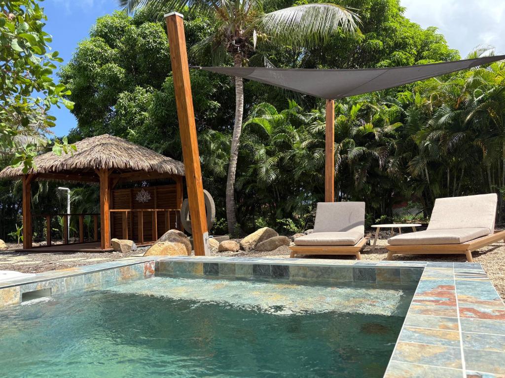 a swimming pool with two chairs and an umbrella at Domaine Saint-François in Saint-François