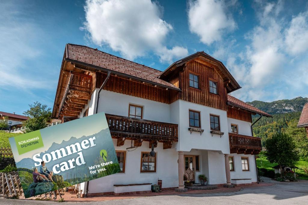 een gebouw met een bord ervoor bij BioHAUS in Haus im Ennstal