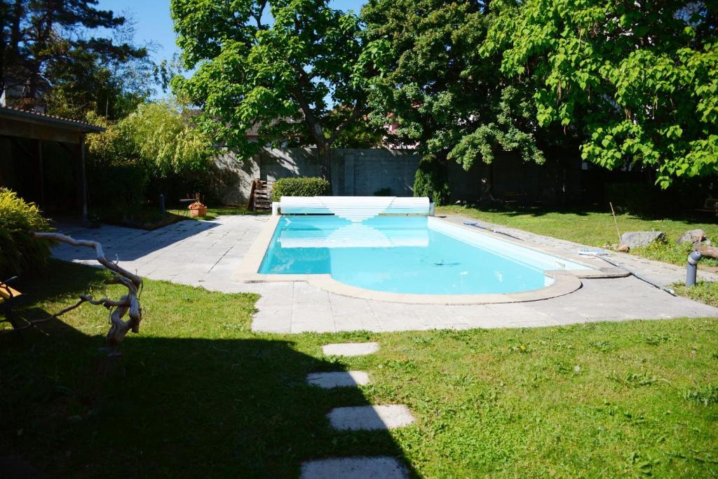 a small swimming pool in a yard with a grass field at La Passerelle de la Doller in Reiningue