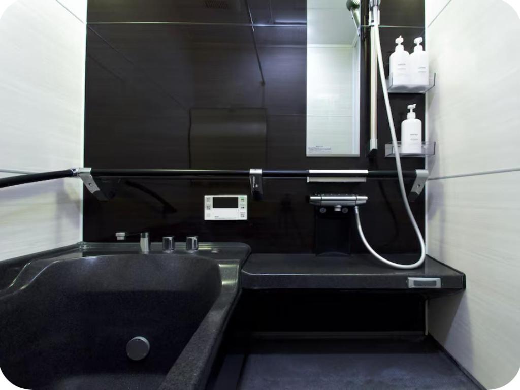 Un baño con un lavabo negro y un espejo. en 楓の宿1號館, en Osaka
