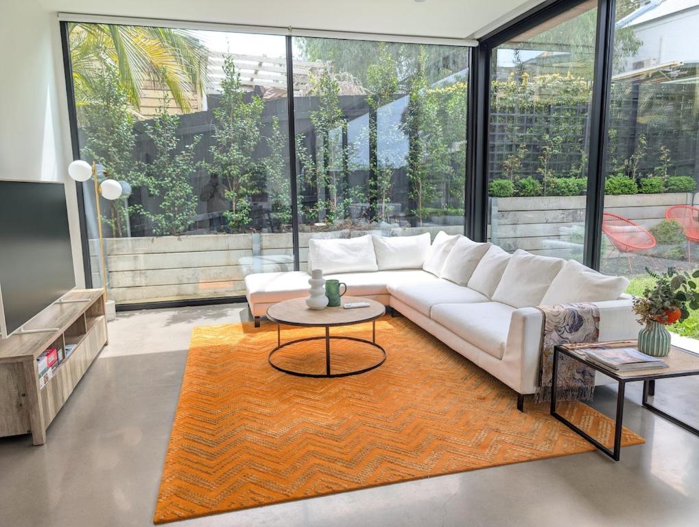 a living room with a white couch and a table at Donatella, Where Heritage Meets Haute Living in Bendigo
