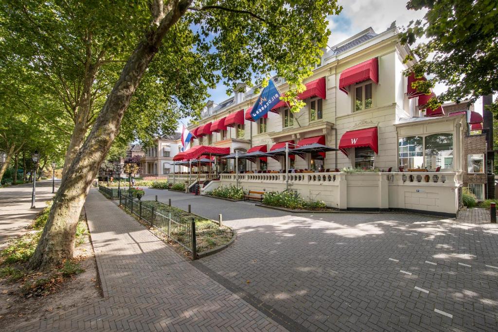 a building with red umbrellas on a city street at Bilderberg Grand Hotel Wientjes in Zwolle
