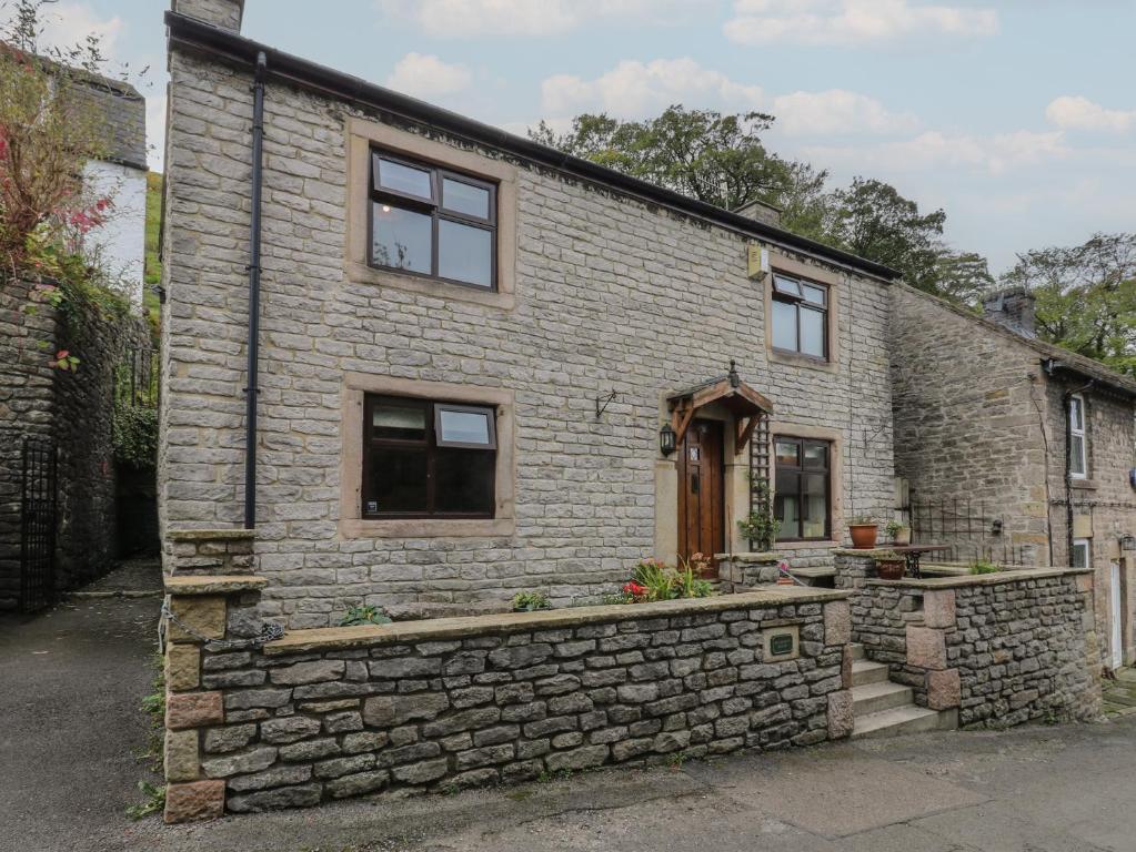 a stone house with a stone wall at Bradshaw House in Castleton
