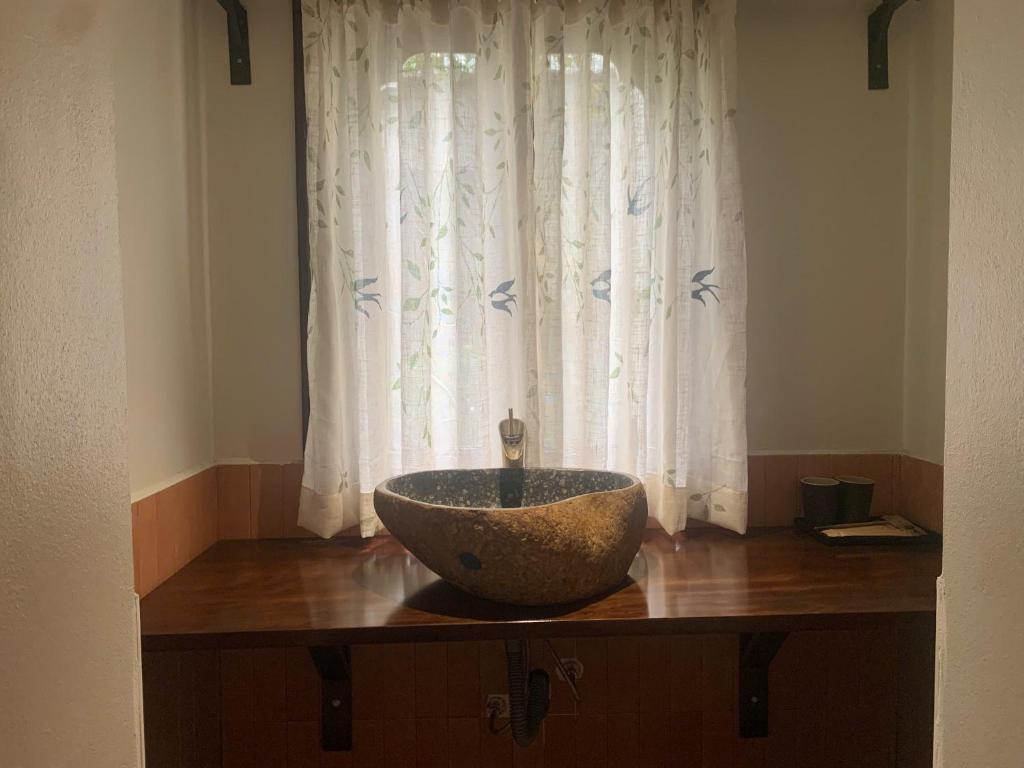 a bowl sink on a wooden counter in front of a window at Châu Home in Ninh Binh
