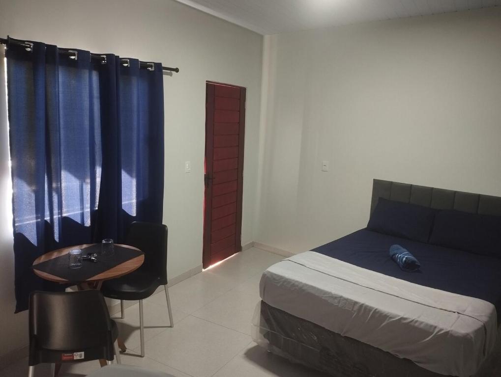 een slaapkamer met een bed, een tafel en een stoel bij Comfortable studio, well located in Macapá