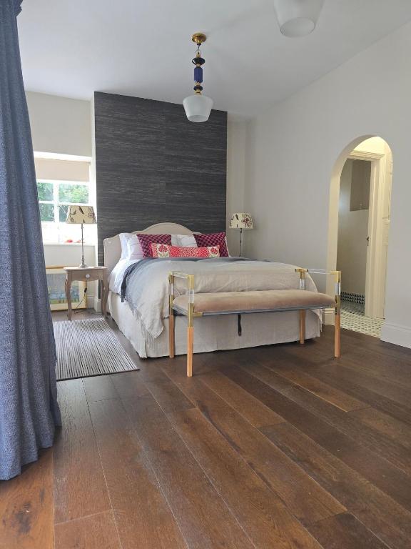 Un dormitorio con una cama y suelo de madera. en Accommodation in Dorset, Sherborne, en Sherborne