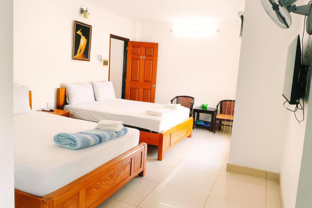 Khải Lộc Minh Hotel Hồ Chí Minh في مدينة هوشي منه: غرفة بسريرين وتلفزيون فيها