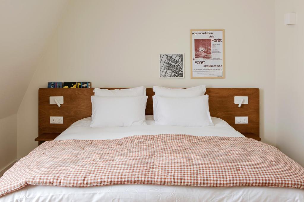 a bedroom with a bed with white sheets and pillows at Alfred Hotels Compiègne in Compiègne