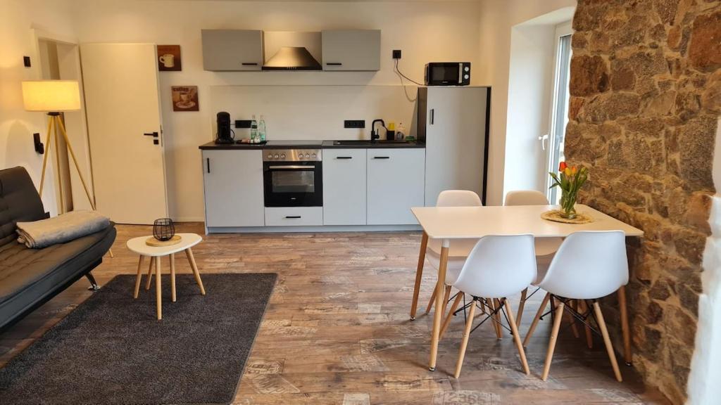 a kitchen and a living room with a table and chairs at Modernes Apartment im grünen in Kleines Wiesental