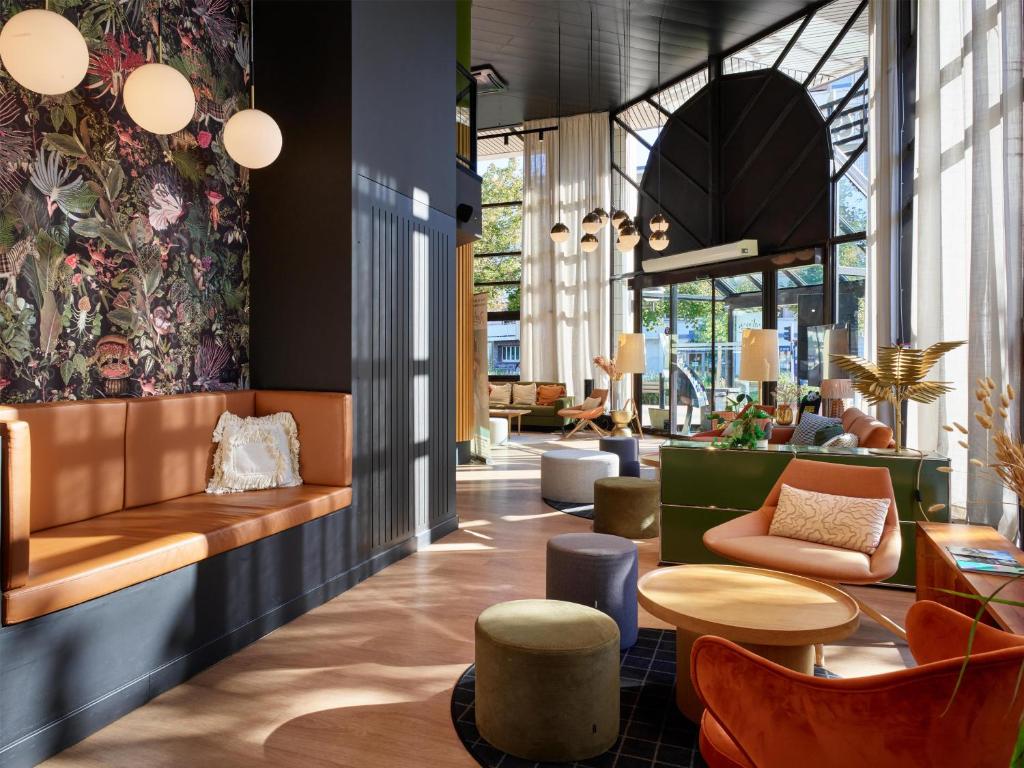 a lobby with chairs and tables in a building at Radisson Hotel Clermont-Ferrand in Clermont-Ferrand