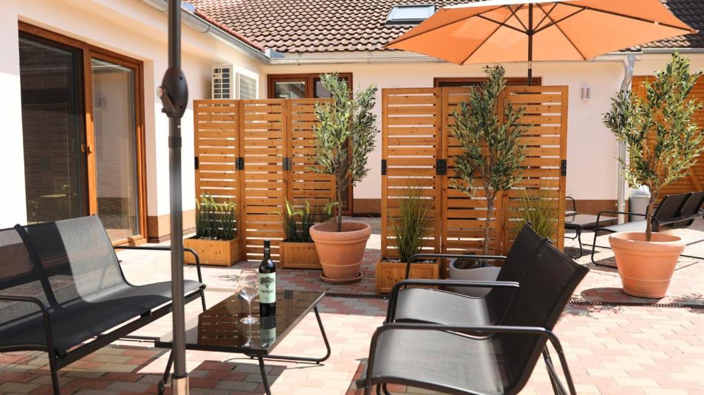 a patio with chairs and a table and an umbrella at Petříkovy Apartmány in Bulhary