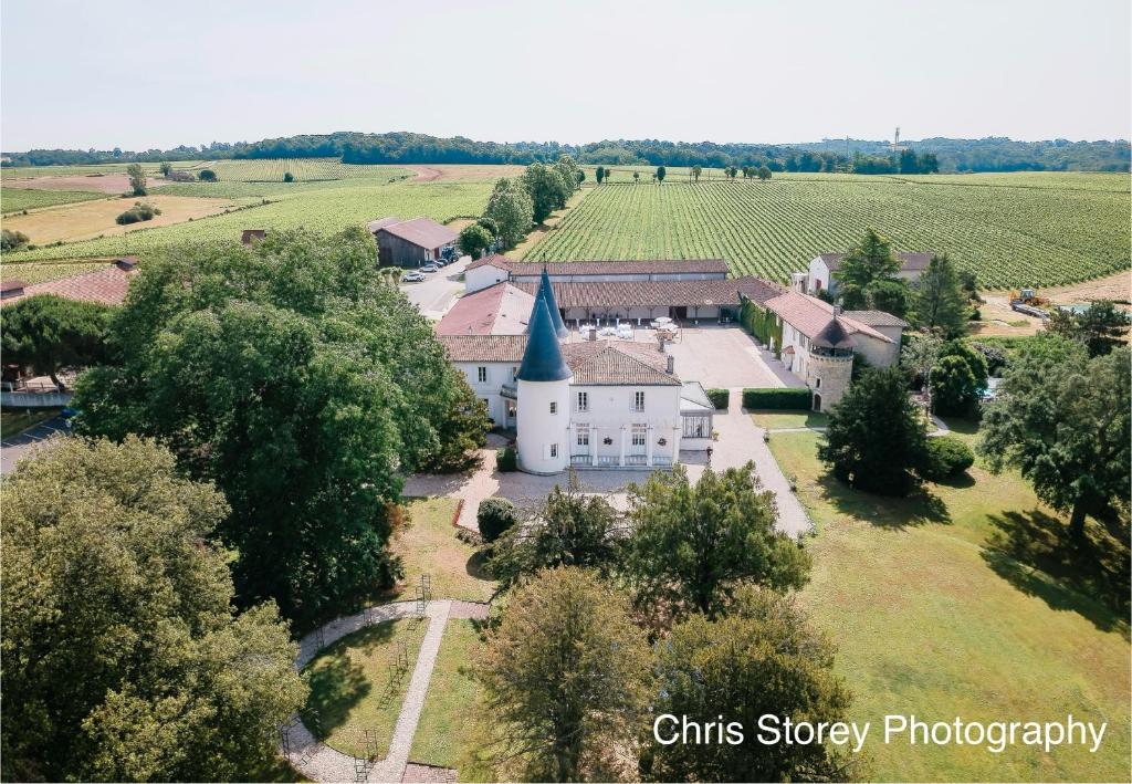 an aerial view of a white building with a church at Chambres d'hôtes du Château de Seguin in Lignan-de-Bordeaux