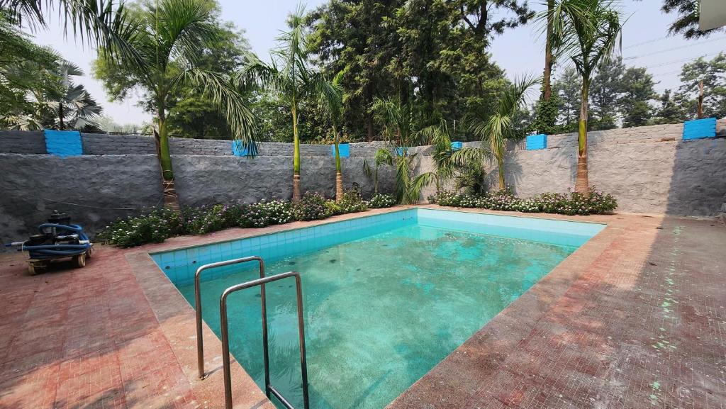 a swimming pool in the middle of a yard at Saanjh Farm in Gurgaon
