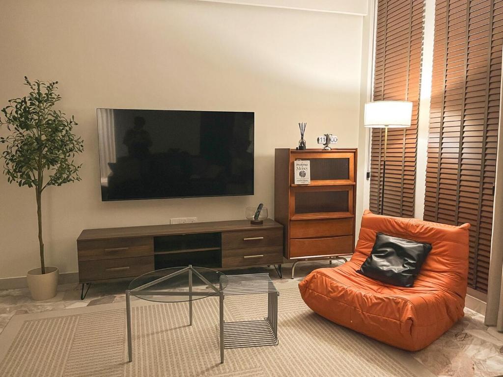 un salon avec une télévision à écran plat et une chaise dans l'établissement Haven Homestay, à Batu Pahat