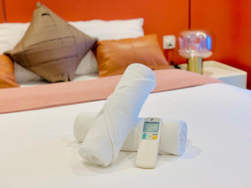 a bed with white socks and a thermometer on it at Eaton Delight Residences in Kuala Lumpur