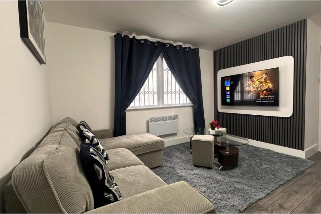 a living room with a couch and a flat screen tv at Apartment - Sleeps 4 - City Base - District Line in Dagenham Dock