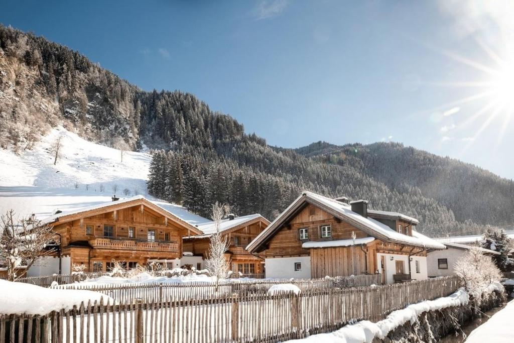 a log cabin in the snow with a fence at Chalet Frauenkogel in Grossarl