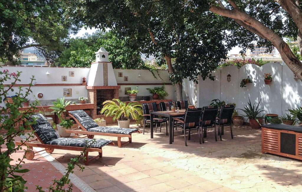 a patio with a table and chairs and a fireplace at 2 Bedroom Beautiful Home In Benalmadena in Benalmadena Costa