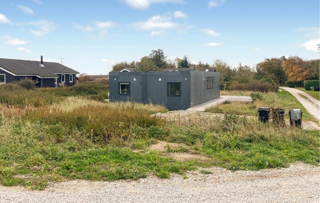 a building in a field next to a road at 3 Bedroom Beautiful Home In Hurup Thy in Doverodde