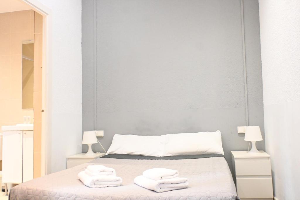 a bedroom with a bed with towels on it at Homenfun Barcelona Camp Nou in Hospitalet de Llobregat
