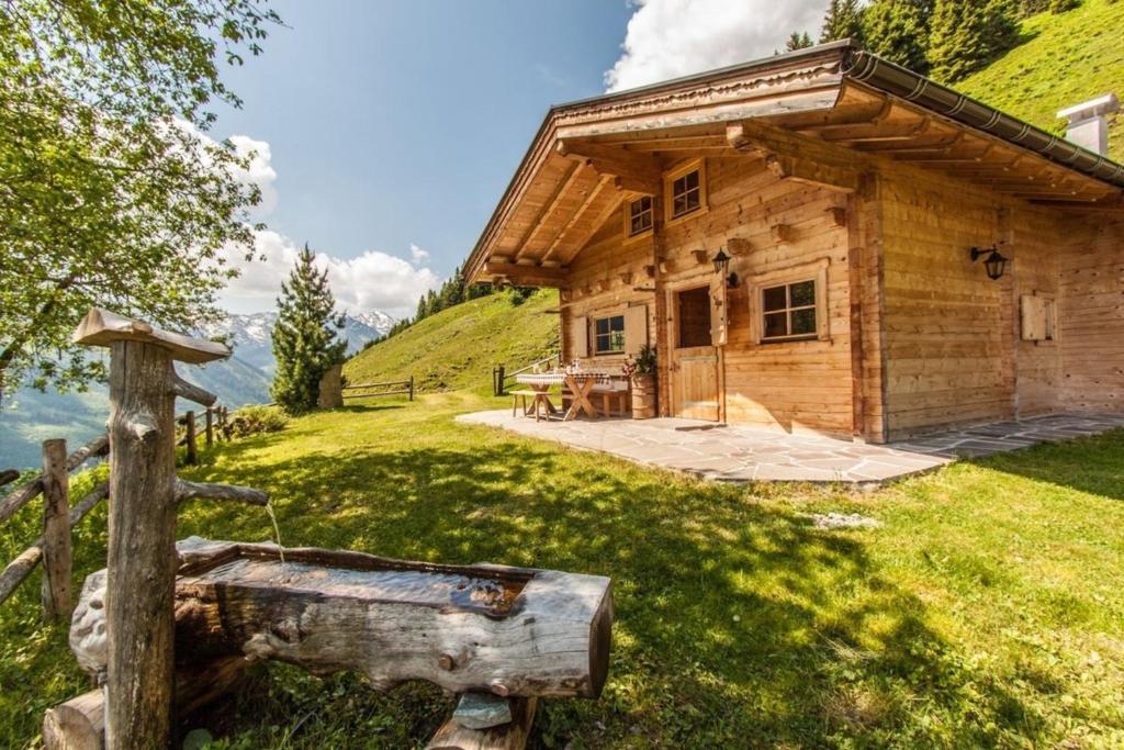 a log cabin with a table in front of it at Berghütte Kelchsau in Kelchsau