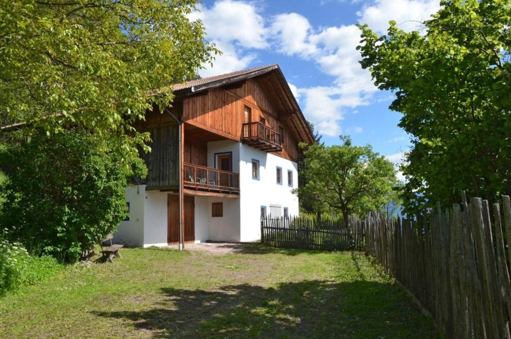 a house with a wooden fence in front of it at Kohlstatt Hütte in Verano