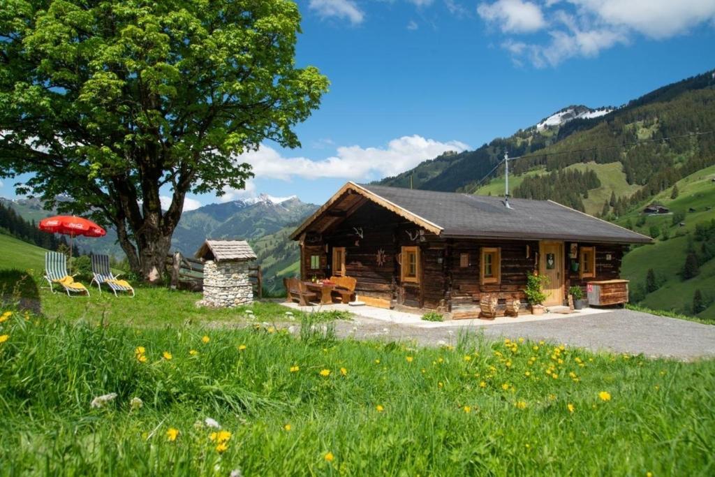 a log cabin in a field with a tree at Hungarhub Hütte in Grossarl