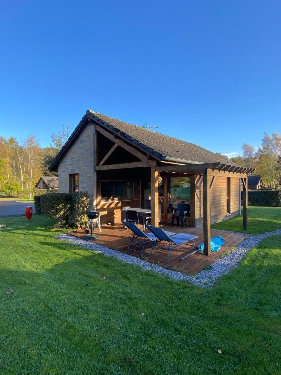 a house with a deck and chairs in the yard at Gîte au calme en pleine nature in Signy-le-Petit