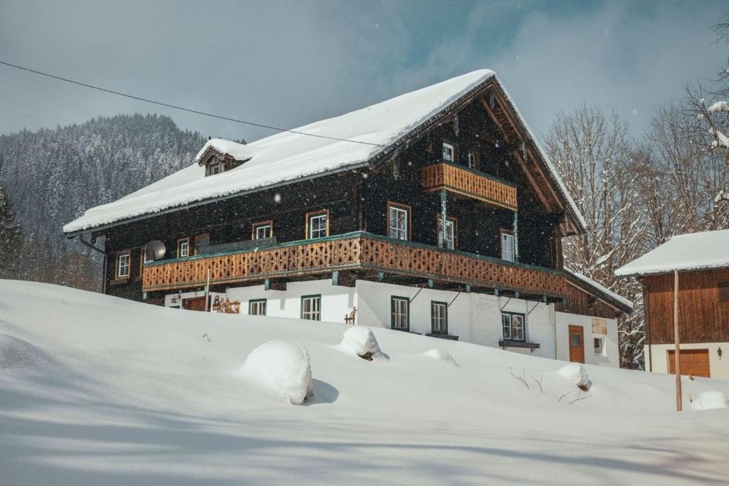 a large building covered in snow in front of a road at Bauernhaus Lammertal in Sankt Martin am Tennengebirge