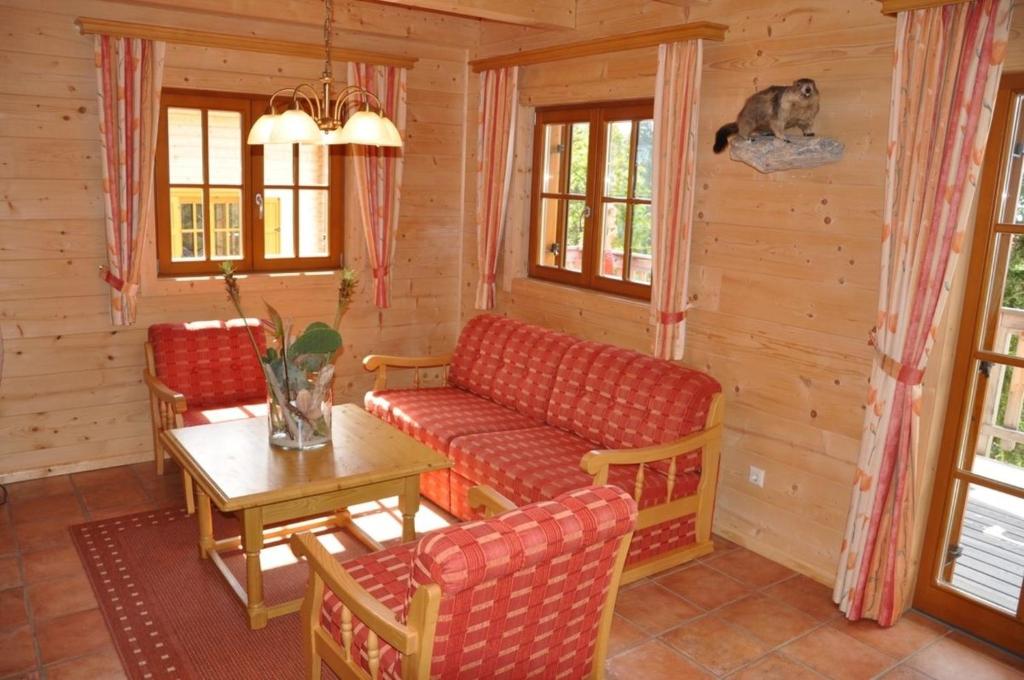 a living room with a couch and a table at Almliebe-Feriendorf Koralpe in Elsenbrunn