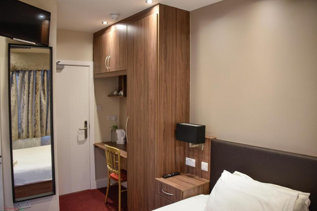 ミッチャムにあるCasuarina Treeのベッドと机があるホテルの部屋