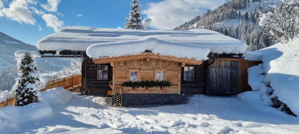 a log cabin covered in snow in the mountains at Faschinghütte in Mühlbach am Hochkönig