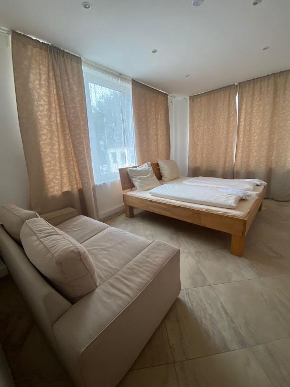 a bedroom with a bed and a couch and a window at Haven Hannover in Hannover