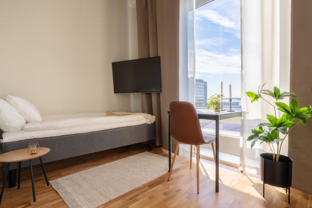 Kleines Zimmer mit einem Bett, einem Schreibtisch und einem Fenster in der Unterkunft Forenom Aparthotel Luleå Västra Stranden in Luleå