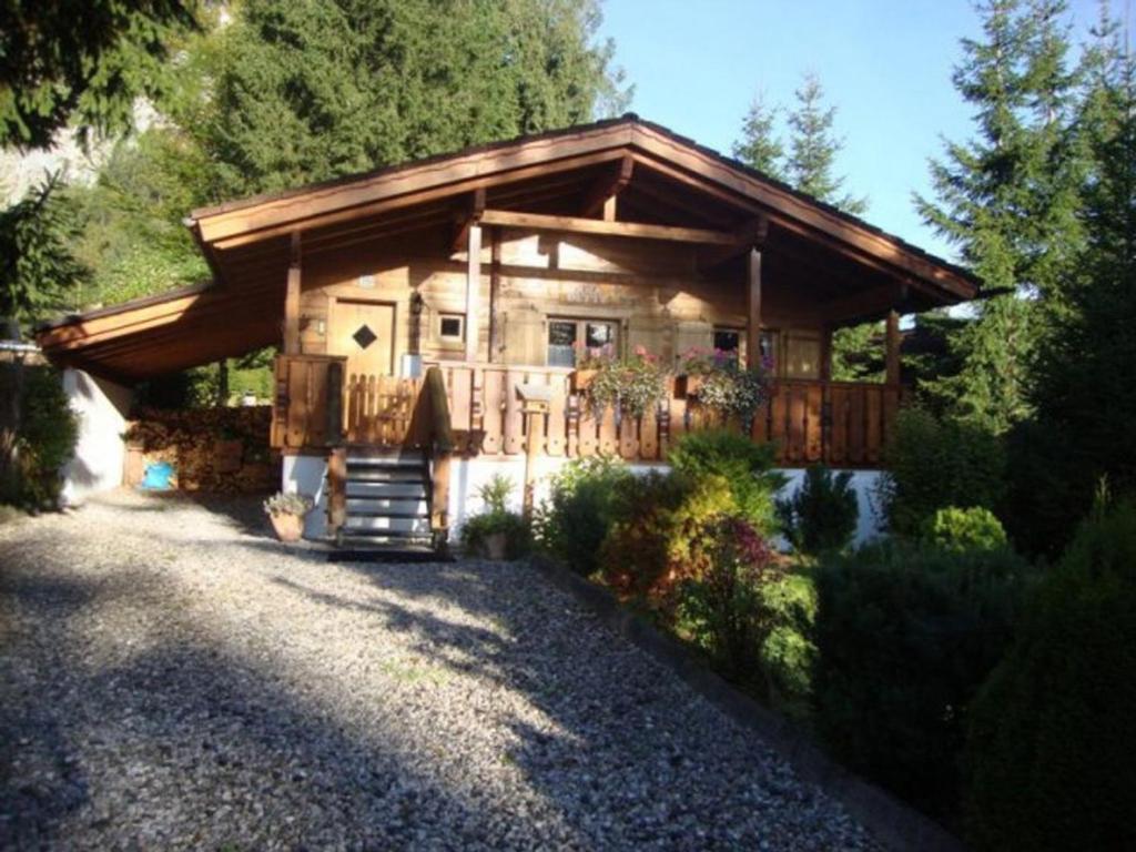 a log cabin in the woods with a driveway at Alpen-Chalets Achensee in Häusern
