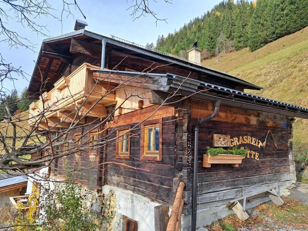 una cabaña de madera a un lado de una montaña en Grasreithütte, en Schied